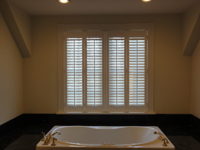 Interior shutters over a bathtub