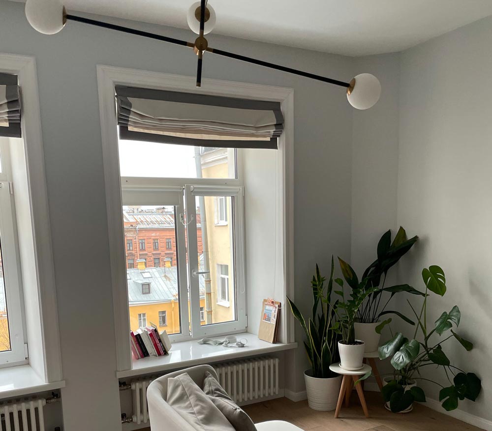 A window with grey and white roman shades